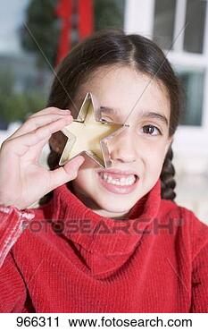 Stock Photography - girl holding cut-out 
biscuit in front 
of her eye. fotosearch 
- search stock 
photos, pictures, 
images, and photo 
clipart