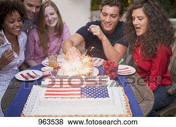 Stock Photo - man lighting sparklers 
on cake (4th of 
july, usa). fotosearch 
- search stock 
photos, pictures, 
images, and photo 
clipart