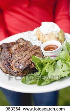 Stock Photo - person holding 
plate of grilled 
steak, baked potato 
& salad. fotosearch 
- search stock 
photos, pictures, 
images, and photo 
clipart