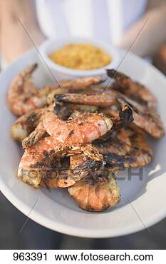Stock Photography - person holding 
plate of grilled 
shrimps. fotosearch 
- search stock 
photos, pictures, 
images, and photo 
clipart