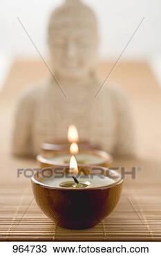 Stock Photo - three tea lights 
on bamboo mat 
in front of buddha 
statue. fotosearch 
- search stock 
photos, pictures, 
images, and photo 
clipart