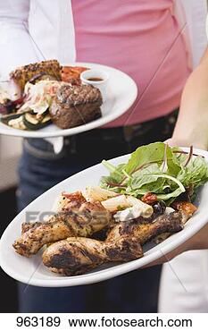 Stock Photograph - two people holding 
plates of grilled 
food (different). 
fotosearch - search 
stock photos, 
pictures, images, 
and photo clipart