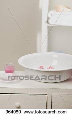 Stock Photography - wash bowl with 
flowers, soap, 
candle in glass 
in bathroom. fotosearch 
- search stock 
photos, pictures, 
images, and photo 
clipart