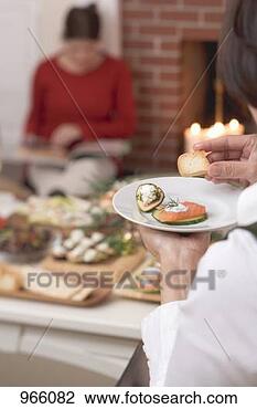Stock Photo - woman eating appetisers, 
woman in background 
reading a book. 
fotosearch - search 
stock photos, 
pictures, images, 
and photo clipart