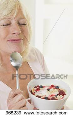Stock Photograph - woman enjoying 
yoghurt with berries 
and flaked almonds. 
fotosearch - search 
stock photos, 
pictures, images, 
and photo clipart