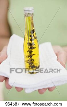 Picture - woman holding 
bottle of body 
oil on towel. 
fotosearch - search 
stock photos, 
pictures, images, 
and photo clipart