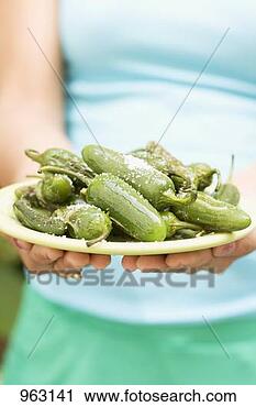 Stock Photography - woman holding 
plate of grilled, 
seasoned chillies. 
fotosearch - search 
stock photos, 
pictures, images, 
and photo clipart