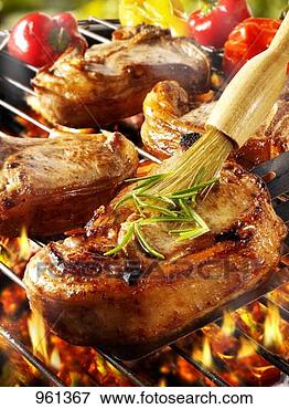 Picture - brushing pork 
chop on barbecue 
rack with oil. 
fotosearch - search 
stock photos, 
pictures, images, 
and photo clipart