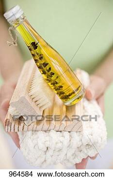 Stock Photo - woman holding 
bottle of body 
oil, soap dish, 
brush & towel. 
fotosearch - search 
stock photos, 
pictures, images, 
and photo clipart