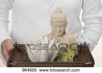 Stock Image - woman holding 
buddha statue, 
candle and orchid 
on tray. fotosearch 
- search stock 
photos, pictures, 
images, and photo 
clipart