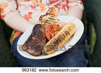 Stock Photo - woman holding 
plate of grilled 
steak and accompaniments. 
fotosearch - search 
stock photos, 
pictures, images, 
and photo clipart