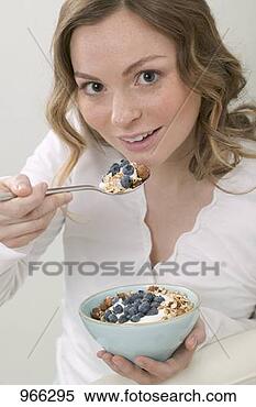 Stock Image - woman eating muesli 
with blueberries. 
fotosearch - search 
stock photos, 
pictures, images, 
and photo clipart