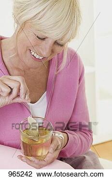 Stock Photo - woman putting 
tea bag into cup 
of hot water. 
fotosearch - search 
stock photos, 
pictures, images, 
and photo clipart
