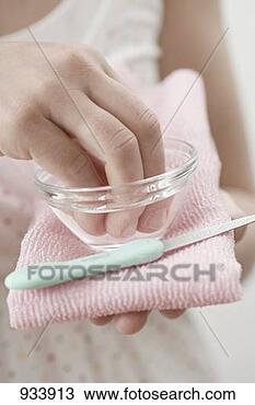 Stock Photo - young woman soaking 
her finger tips 
in a small dish. 
fotosearch - search 
stock photos, 
pictures, images, 
and photo clipart