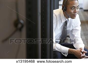 Stock Photo - male office worker 
wearing headset 
sitting in office 
cubicle. fotosearch 
- search stock 
photos, pictures, 
images, and photo 
clipart