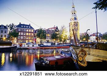 Stock Photography - netherlands, holland, 
amsterdam, montelbaanstoren 
by canal, evening. 
fotosearch - search 
stock photos, 
pictures, images, 
and photo clipart