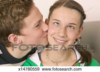 Stock Photograph - teenage boy (13-15) 
kissing teenage 
girl's (12-14) 
cheek, close-up. 
fotosearch - search 
stock photos, 
pictures, images, 
and photo clipart