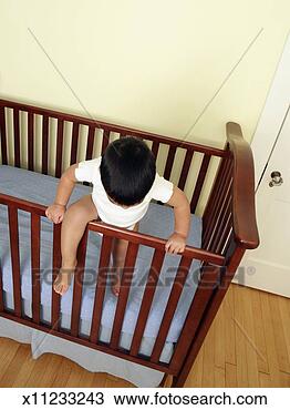 Stock Photo - toddler boy (18-24 
months) climbing 
out of crib, elevated 
view. fotosearch 
- search stock 
photos, pictures, 
images, and photo 
clipart