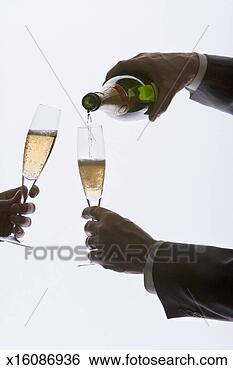 Stock Photo - two men toasting, 
one pouring champagne 
to champagne flute, 
close-up. fotosearch 
- search stock 
photos, pictures, 
images, and photo 
clipart