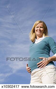 Picture - pregnant mid adult 
woman outdoors, 
 putting hands 
to stomach and. 
fotosearch - search 
stock photos, 
pictures, images, 
and photo clipart
