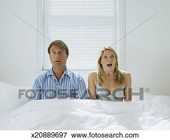 Picture - couple sitting 
in bed, open mouth, 
facial expression. 
fotosearch - search 
stock photos, 
pictures, images, 
and photo clipart