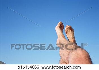 Stock Photo - bare footed man 
with legs crossed 
in air, low section, 
low angle view. 
fotosearch - search 
stock photos, 
pictures, images, 
and photo clipart