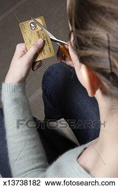 Stock Photo - young woman cutting 
up credit card, 
view over woman's 
shoulder. fotosearch 
- search stock 
photos, pictures, 
images, and photo 
clipart