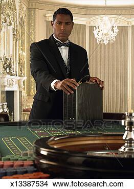 Stock Photo - man standing with 
briefcase at roulette 
table, portrait. 
fotosearch - search 
stock photos, 
pictures, images, 
and photo clipart