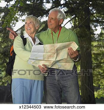 Stock Photo - senior couple 
looking at map 
in park, looking 
away, smiling. 
fotosearch - search 
stock photos, 
pictures, images, 
and photo clipart