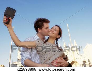 Stock Photo - man embracing 
woman photographing 
self using old 
fashioned camera. 
fotosearch - search 
stock photos, 
pictures, images, 
and photo clipart