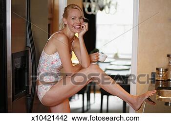 Stock Photo - mid adult woman 
standing in kitchen, 
in underwear, 
portrait. fotosearch 
- search stock 
photos, pictures, 
images, and photo 
clipart