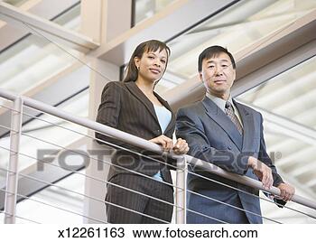 Stock Photo - two business people 
looking down from 
railing in office. 
fotosearch - search 
stock photos, 
pictures, images, 
and photo clipart