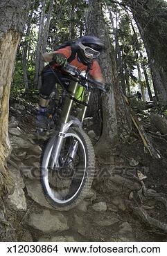 Stock Photo - boy (12-13) mountain 
biking, low angle 
view. fotosearch 
- search stock 
photos, pictures, 
images, and photo 
clipart
