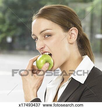 Picture - businesswoman 
biting apple, 
portrait. fotosearch 
- search stock 
photos, pictures, 
images, and photo 
clipart