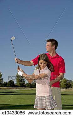 Stock Photo - golf instructor 
teaching young 
female student 
(13-14) putting 
on golf. fotosearch 
- search stock 
photos, pictures, 
images, and photo 
clipart