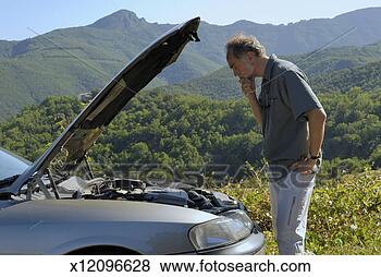 Stock Photo - man with broken 
car in rural setting, 
looking at engine, 
side view. fotosearch 
- search stock 
photos, pictures, 
images, and photo 
clipart