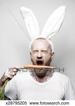 Stock Image - man wearing bunny 
ears, biting carrot 
with eyes shut. 
fotosearch - search 
stock photos, 
pictures, images, 
and photo clipart