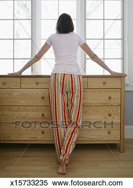 Stock Image - mid adult woman 
wearing pyjamas 
looking out window, 
rear view. fotosearch 
- search stock 
photos, pictures, 
images, and photo 
clipart