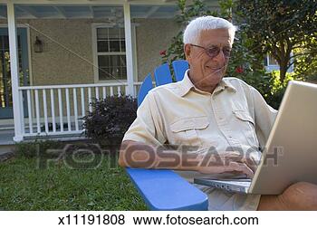Stock Photo - senior man using 
laptop in front 
yard. fotosearch 
- search stock 
photos, pictures, 
images, and photo 
clipart