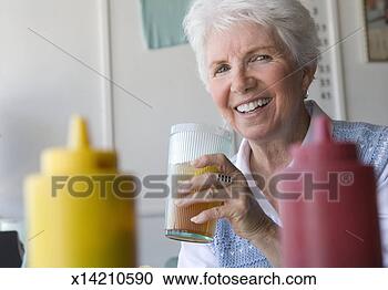 Stock Photography - senior woman drinking 
ice tea in diner. 
fotosearch - search 
stock photos, 
pictures, images, 
and photo clipart