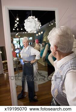 Stock Photography - senior woman trying 
on clothing in 
store. fotosearch 
- search stock 
photos, pictures, 
images, and photo 
clipart