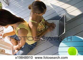 Stock Photography - two young women 
sitting on porch 
using wireless 
technology. fotosearch 
- search stock 
photos, pictures, 
images, and photo 
clipart