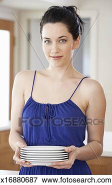 Picture - woman holding 
stack of plates 
in room, portrait. 
fotosearch - search 
stock photos, 
pictures, images, 
and photo clipart