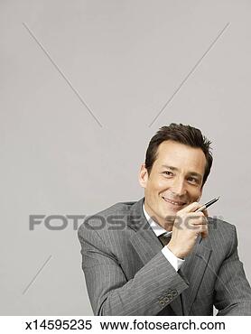 Stock Image - business man holding 
fountain pen, 
studio shot, studio 
shot. fotosearch 
- search stock 
photos, pictures, 
images, and photo 
clipart