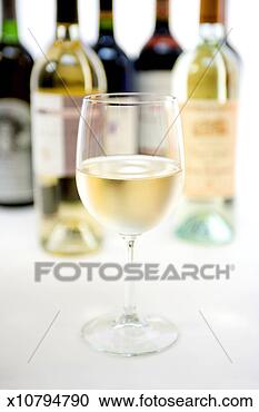 Stock Photography - glass of white 
wine in front 
of wine bottles, 
focus on foreground. 
fotosearch - search 
stock photos, 
pictures, images, 
and photo clipart
