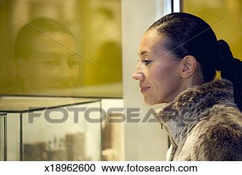 Stock Photography - woman window shopping, 
standing on street, 
side view, close 
up. fotosearch 
- search stock 
photos, pictures, 
images, and photo 
clipart