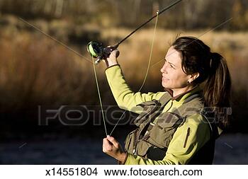 Stock Photo - mid adult woman 
flyfishing, smiling. 
fotosearch - search 
stock photos, 
pictures, images, 
and photo clipart
