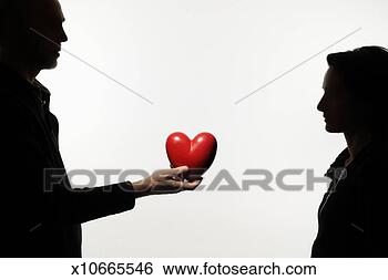Stock Photo - silhouette of 
couple standing 
face to face, 
 man holding heart-shaped. 
fotosearch - search 
stock photos, 
pictures, images, 
and photo clipart