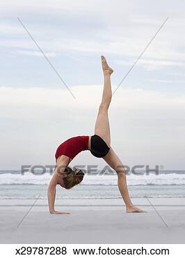 Stock Photo - woman standing 
in yoga pose on 
beach, side view. 
fotosearch - search 
stock photos, 
pictures, images, 
and photo clipart