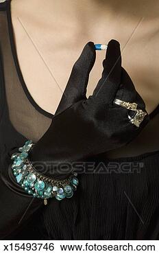 Stock Photo - young woman in 
elegant dress 
and gloves holding 
capsule,  close 
up. fotosearch 
- search stock 
photos, pictures, 
images, and photo 
clipart